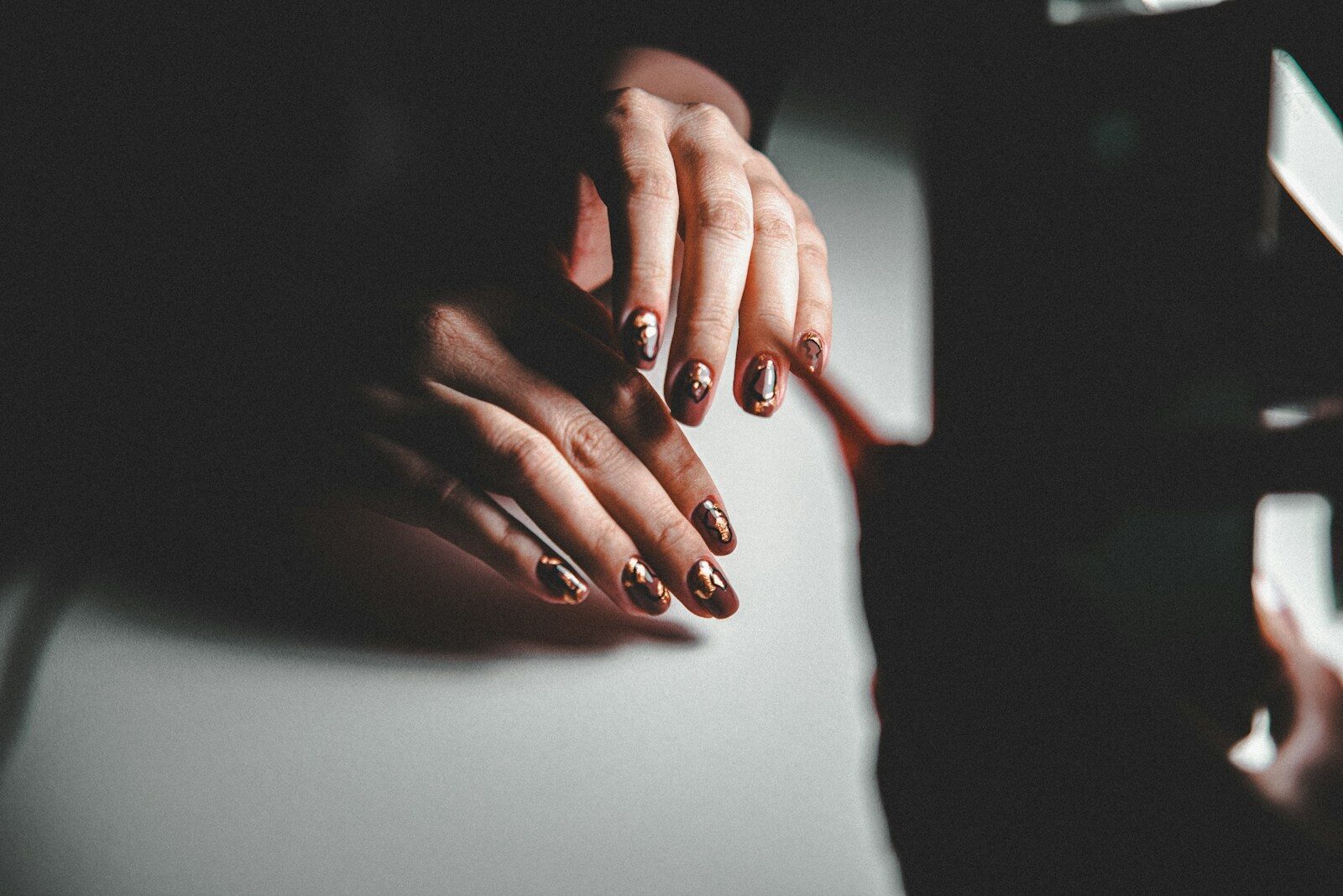 A woman's hands resting on a piano